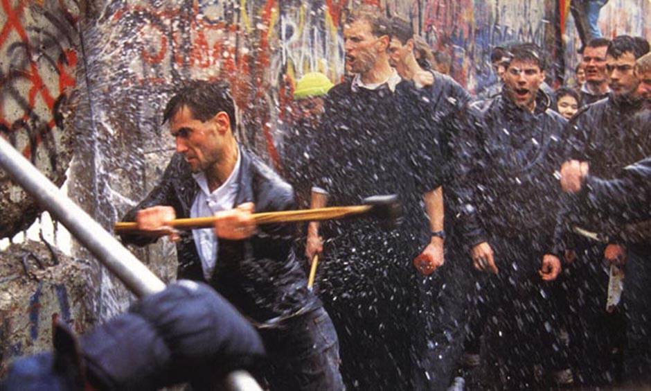 Hombres con mazas tiran el muro de Berlín