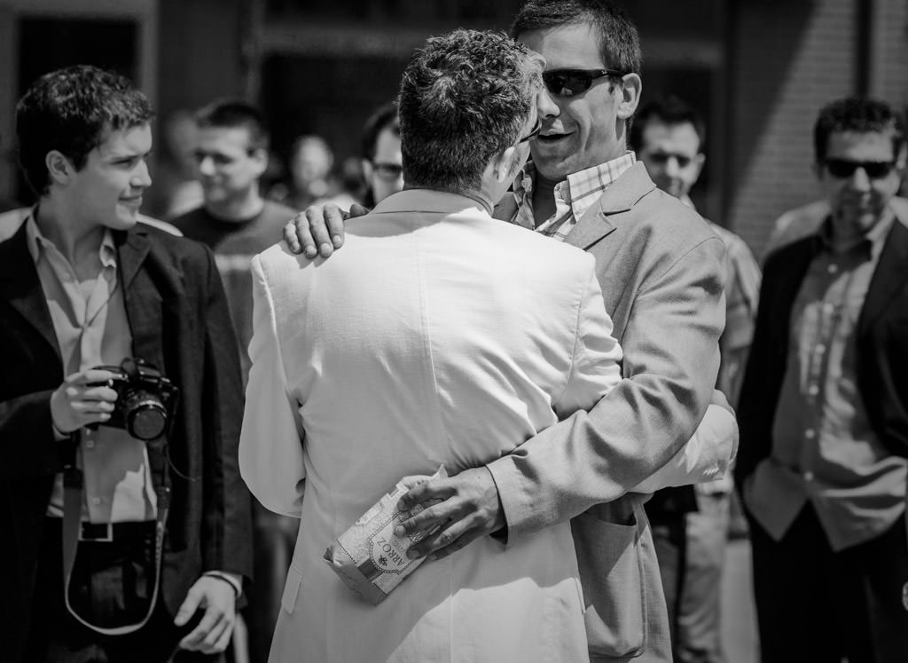 saludo entre el novio e invitado a la boda con paquete de arroz 