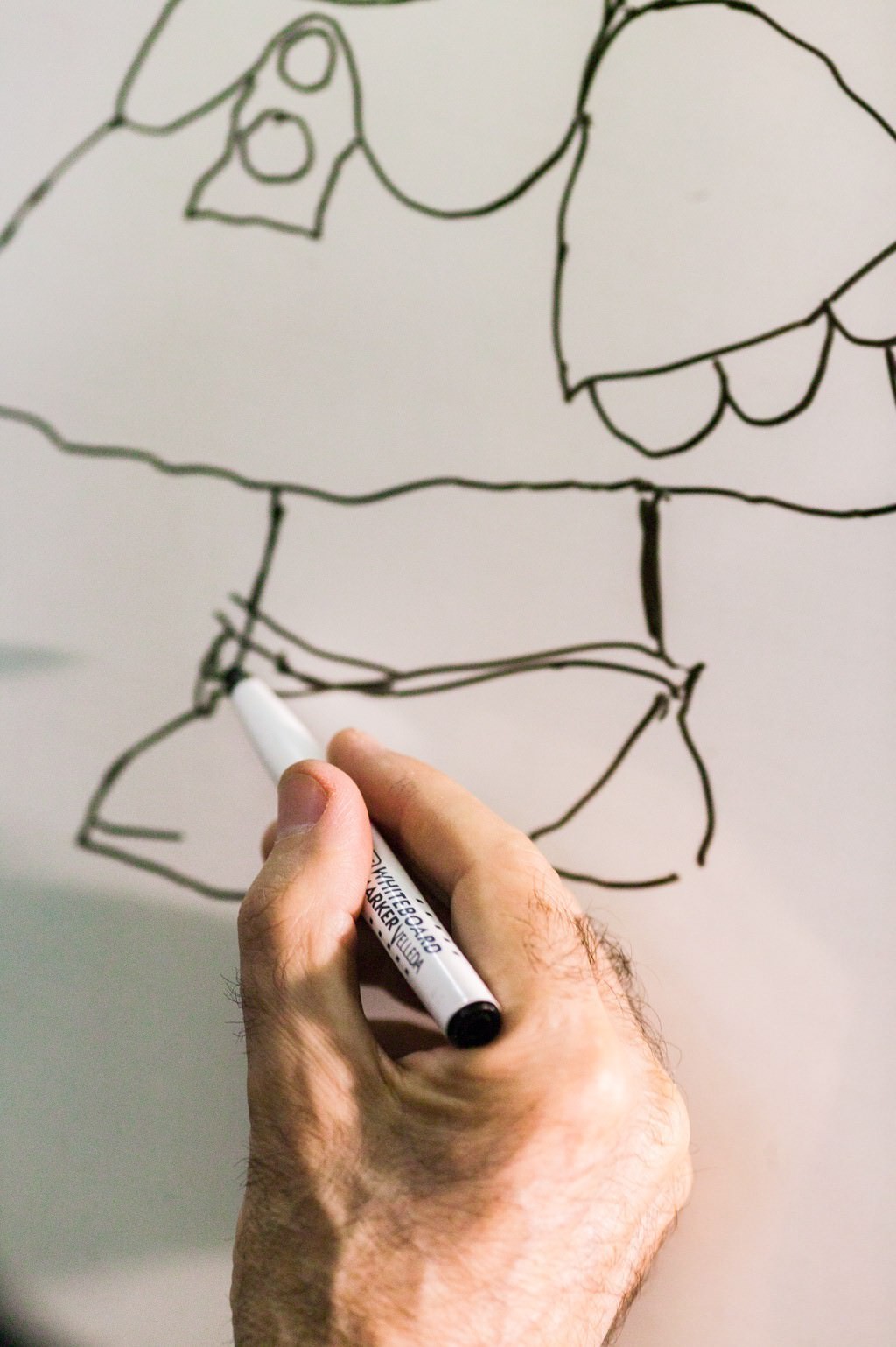 Retratos de Quino dibujando a Mafalda en una pizarra