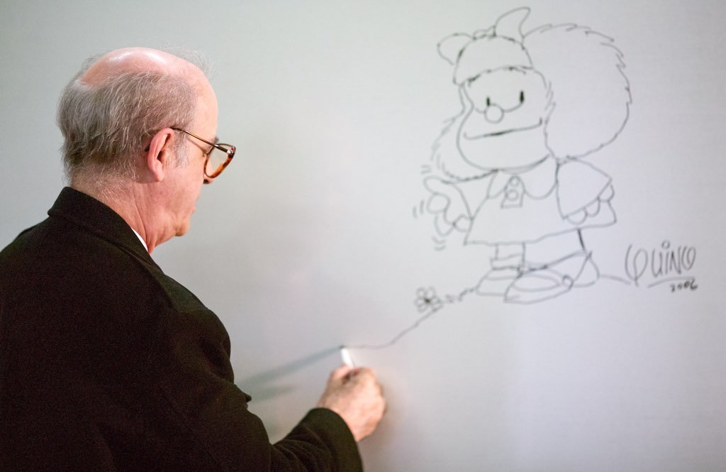 Retratos de Quino dibujando a Mafalda en una pizarra